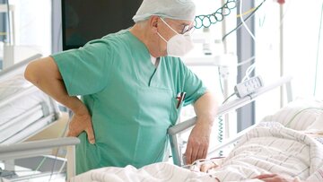 Anästhesist begrüßt Patienten im Aufwachraum.