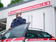 Leitender Notarzt telefoniert vor Unfallchirurgie.